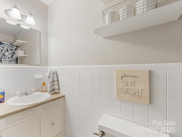 bathroom featuring vanity, tile walls, and wainscoting