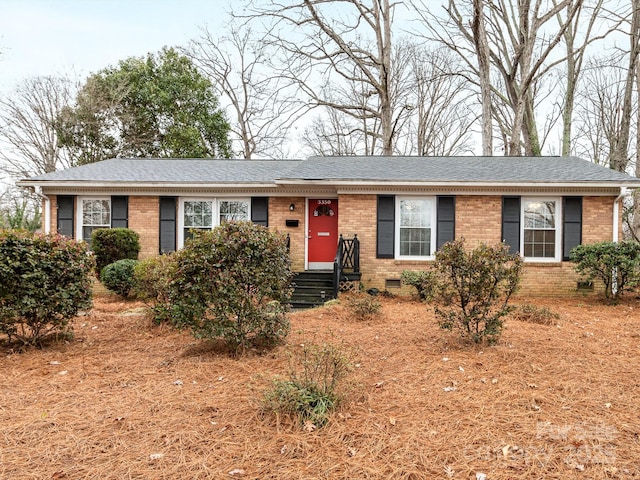 ranch-style home with crawl space, brick siding, and roof with shingles