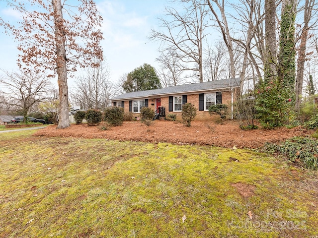 single story home featuring brick siding and a front lawn