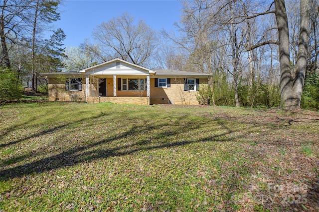 view of front of property featuring crawl space, brick siding, a porch, and a front yard