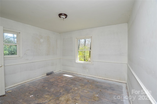 empty room featuring a wainscoted wall