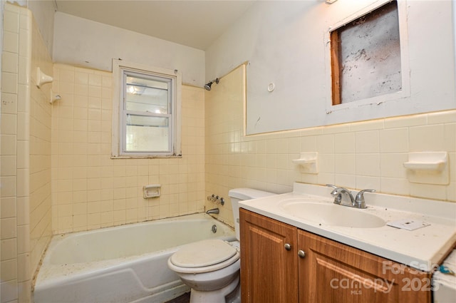 bathroom featuring toilet, tile walls, wainscoting, bathing tub / shower combination, and vanity