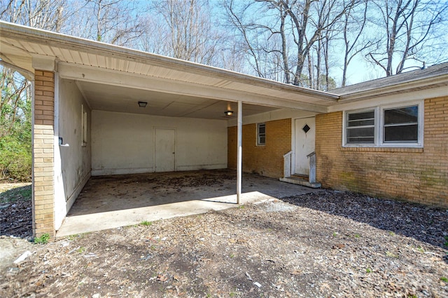 view of parking / parking lot featuring an attached carport, driveway, and entry steps