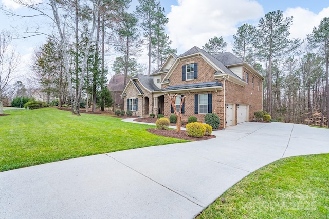 view of front of home featuring brick siding, a front yard, driveway, an attached garage, and a standing seam roof