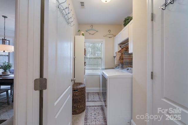 laundry area featuring visible vents, cabinet space, separate washer and dryer, light tile patterned floors, and baseboards