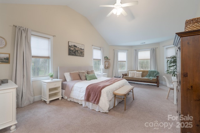 bedroom with a ceiling fan, lofted ceiling, multiple windows, and light colored carpet