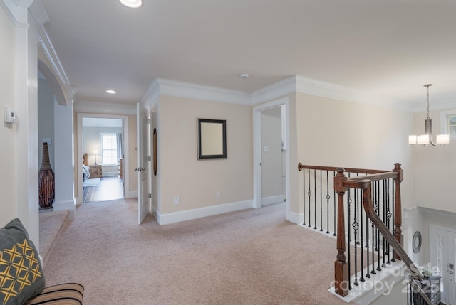 hallway with baseboards, an upstairs landing, light colored carpet, and ornamental molding