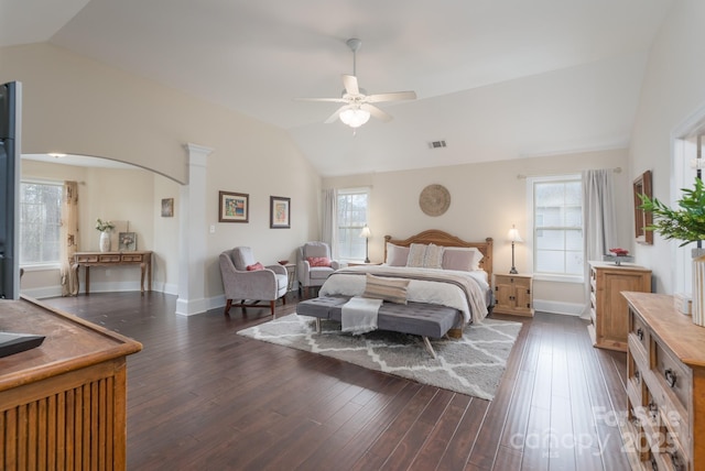 bedroom featuring vaulted ceiling, arched walkways, visible vents, and dark wood-type flooring