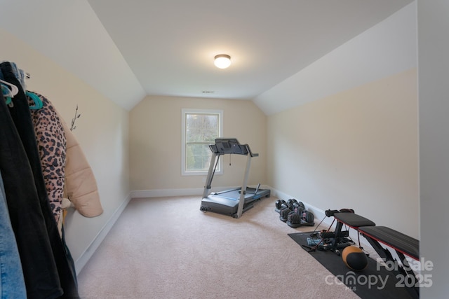 workout area featuring light carpet, visible vents, baseboards, and lofted ceiling