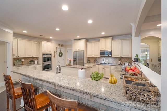 303 Ridge Reserve Dr Unit 29, Clover, SC 29710 - kitchen with stainless steel appliances, ornamental molding, arched walkways, light stone countertops, and recessed lighting