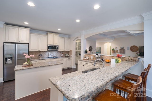 303 Ridge Reserve Dr Unit 29, Clover, SC 29710 - kitchen featuring stainless steel appliances, a kitchen island, arched walkways, decorative backsplash, and ornamental molding