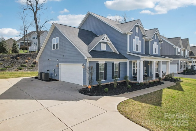 view of front of house featuring a residential view, board and batten siding, concrete driveway, a front yard, and an attached garage