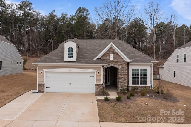 view of front of home with a garage, stone siding, and driveway