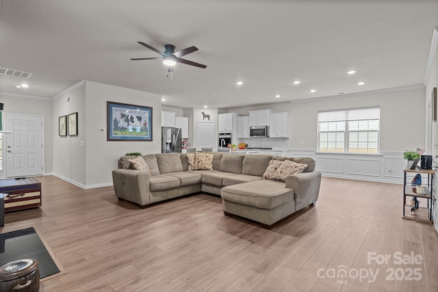 living room featuring visible vents, crown molding, recessed lighting, light wood-style flooring, and a ceiling fan