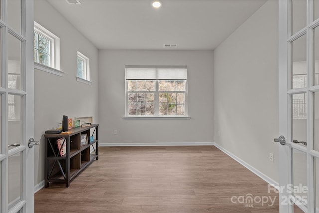 unfurnished room featuring visible vents, french doors, light wood-type flooring, and baseboards