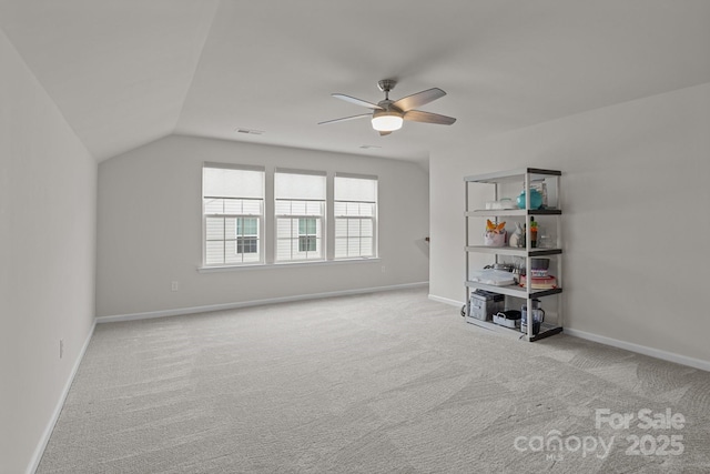 interior space featuring lofted ceiling, carpet flooring, baseboards, and visible vents