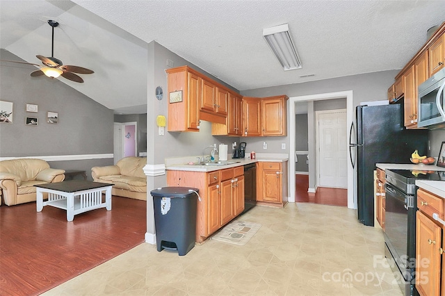 kitchen featuring a ceiling fan, black appliances, light countertops, vaulted ceiling, and open floor plan