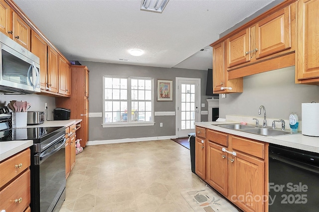 kitchen featuring a sink, visible vents, black appliances, and light countertops