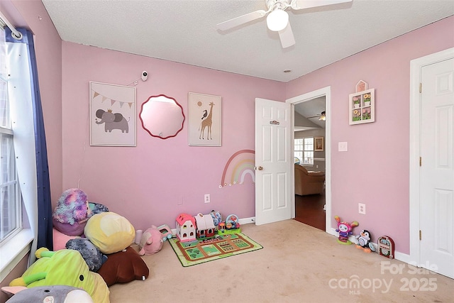 playroom with carpet floors, a textured ceiling, and ceiling fan