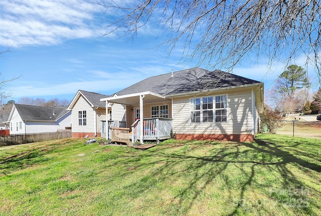 back of property featuring a lawn and fence