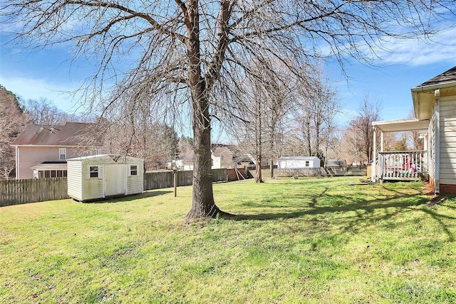 view of yard featuring a fenced backyard, a storage unit, and an outdoor structure