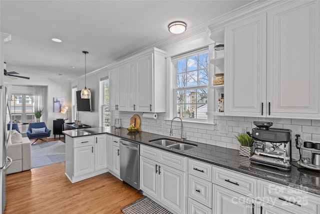 kitchen with light wood finished floors, white cabinetry, a sink, dishwasher, and open floor plan