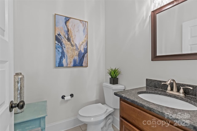 half bath with tile patterned floors, baseboards, toilet, and vanity