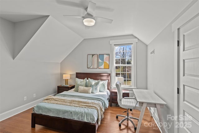 bedroom with baseboards, hardwood / wood-style floors, a ceiling fan, and vaulted ceiling