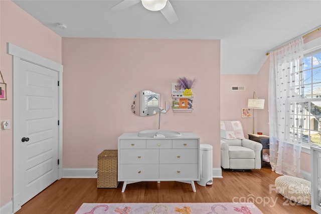 sitting room with wood finished floors, baseboards, visible vents, lofted ceiling, and ceiling fan