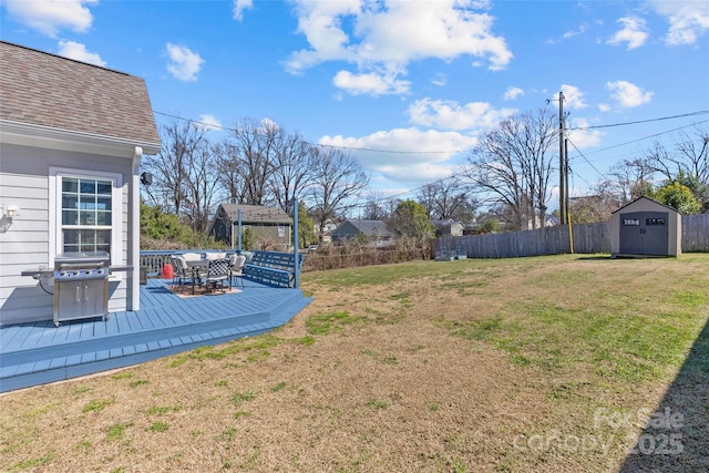 view of yard with a storage unit, a deck, fence, an outdoor structure, and outdoor dining area