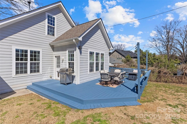 deck with a lawn, a grill, and fence