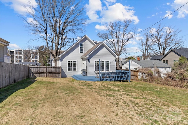 rear view of property with a yard and a fenced backyard