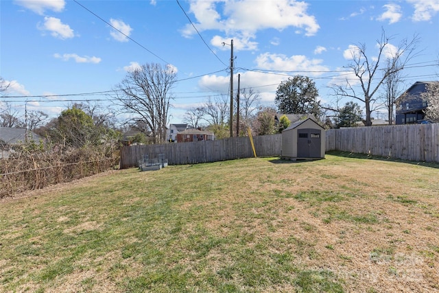 view of yard featuring an outbuilding, a storage unit, and a fenced backyard