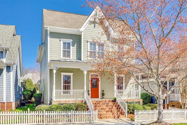 view of front of property with a fenced front yard, central AC unit, a porch, and a shingled roof