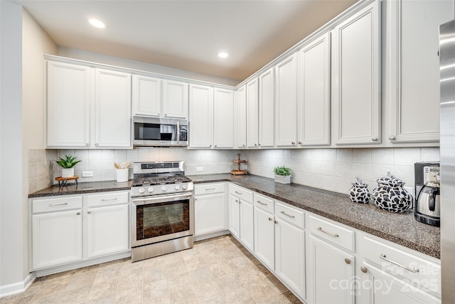 kitchen featuring recessed lighting, stainless steel appliances, dark stone counters, white cabinets, and decorative backsplash