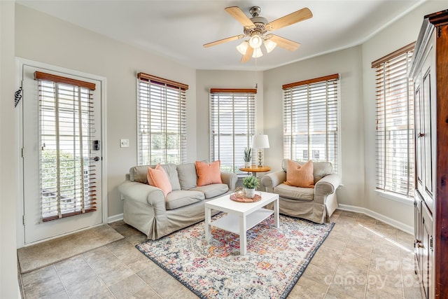 living room featuring a ceiling fan and baseboards