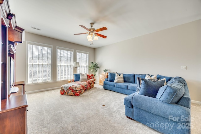 carpeted living room with visible vents, baseboards, and a ceiling fan