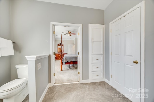 bathroom with tile patterned floors, baseboards, toilet, and ensuite bathroom