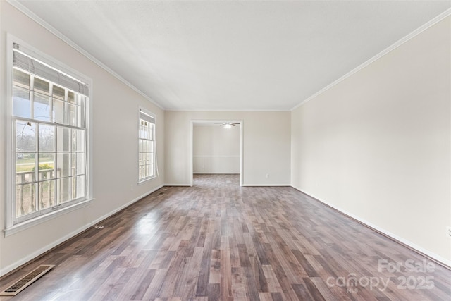 empty room featuring visible vents, crown molding, and wood finished floors