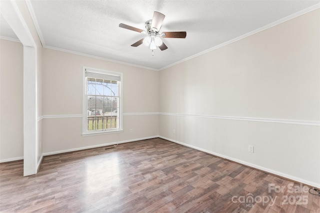 spare room with ceiling fan, a textured ceiling, wood finished floors, and crown molding