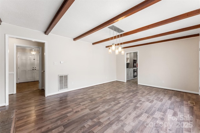 unfurnished living room with visible vents, beamed ceiling, an inviting chandelier, baseboards, and dark wood-style flooring