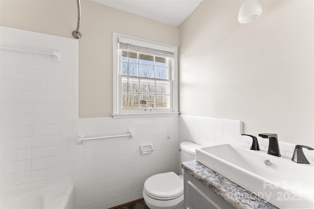 full bath with a wainscoted wall, toilet, tile walls, and vanity