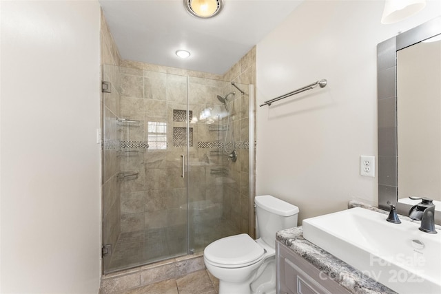 bathroom with a shower stall, toilet, and vanity