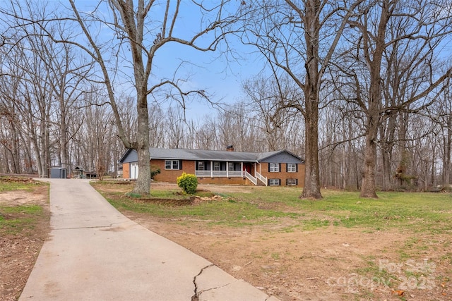 view of front of house with brick siding, a chimney, and a front lawn