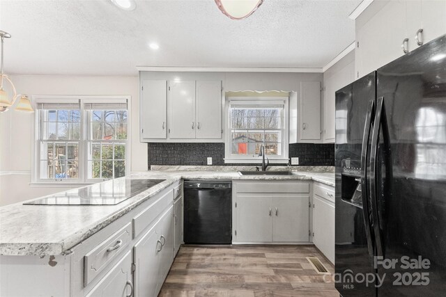 822 Bethlehem Rd, Kings Mountain, NC 28086 - kitchen featuring black appliances, a sink, a textured ceiling, light wood-style floors, and a peninsula