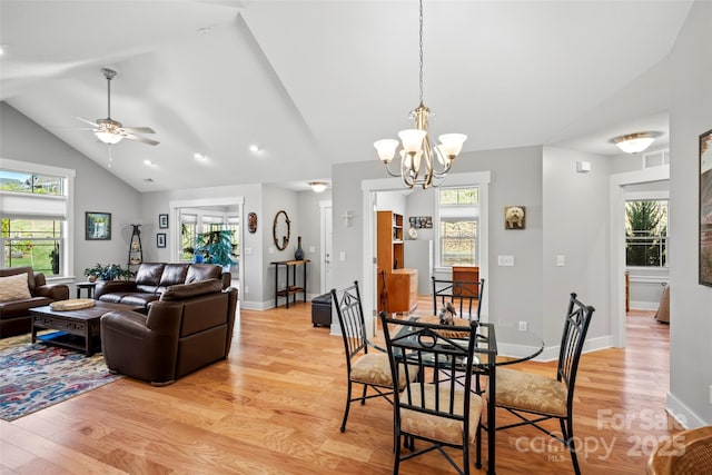 dining area with plenty of natural light, ceiling fan with notable chandelier, baseboards, and light wood finished floors