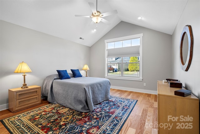 bedroom featuring a ceiling fan, baseboards, visible vents, light wood finished floors, and lofted ceiling