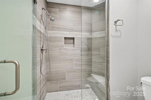 full bath with a stall shower and toilet