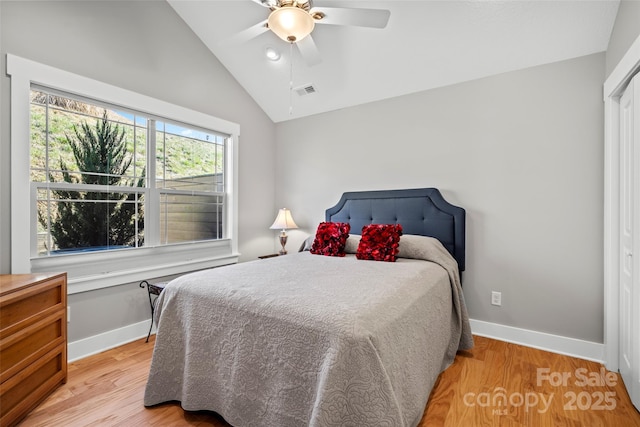 bedroom featuring light wood-style flooring, baseboards, lofted ceiling, and a ceiling fan