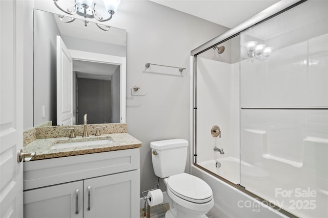 full bathroom featuring vanity, toilet, and bath / shower combo with glass door